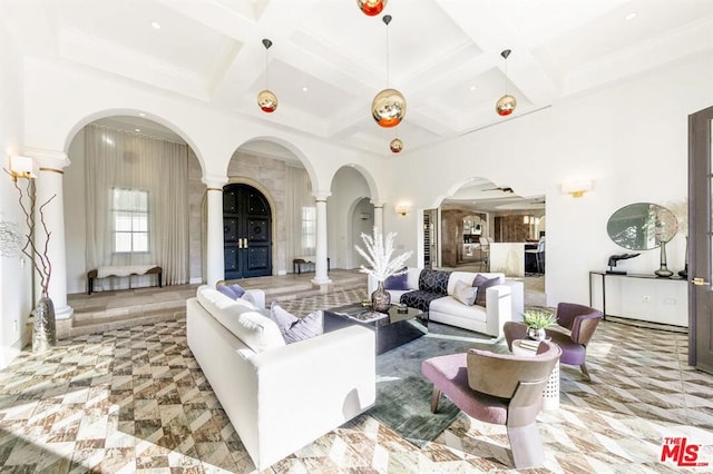 living area featuring a towering ceiling, ornate columns, beam ceiling, coffered ceiling, and arched walkways