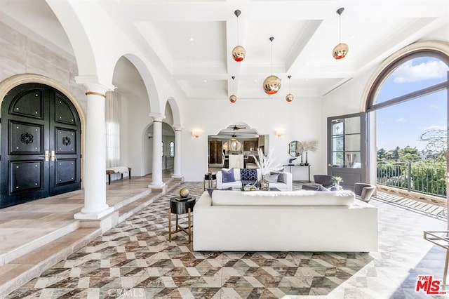 living room with coffered ceiling, beamed ceiling, ornate columns, and a high ceiling