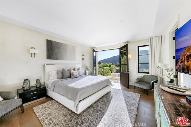 bedroom with access to outside and wood finished floors