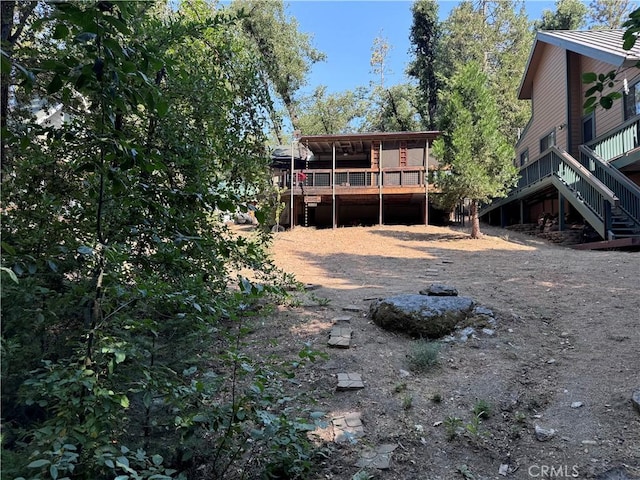 back of house featuring stairs and a deck