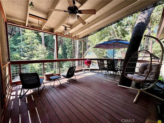wooden terrace featuring outdoor dining space and a ceiling fan