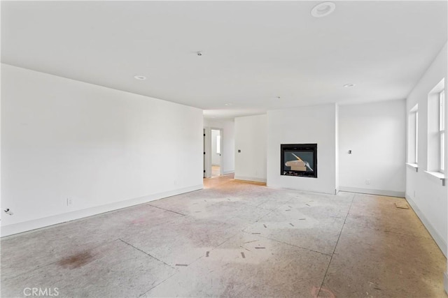 unfurnished living room with a fireplace and baseboards