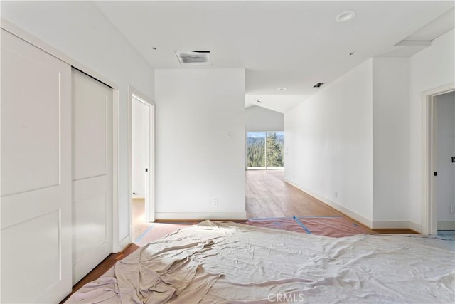 interior space with visible vents, recessed lighting, wood finished floors, lofted ceiling, and baseboards