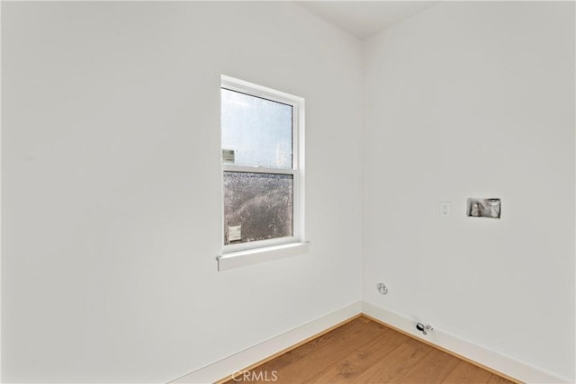 clothes washing area with light wood-style flooring, laundry area, and baseboards