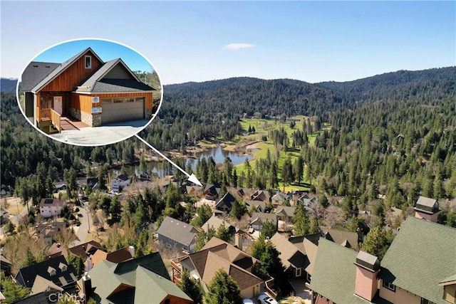 drone / aerial view with a wooded view, a water and mountain view, and a residential view