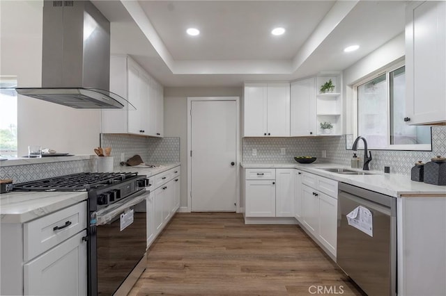 9128 Gerald Ave, Northridge, CA 91343 - kitchen featuring appliances with stainless steel finishes, wall chimney range hood, a sink, a raised ceiling, and light wood-style floors