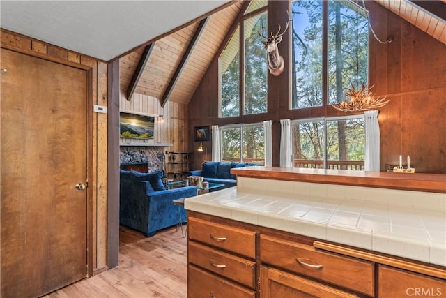 26375 Augusta Dr, Lake Arrowhead, CA 92352 - kitchen with light wood-style floors, brown cabinetry, beam ceiling, and tile counters