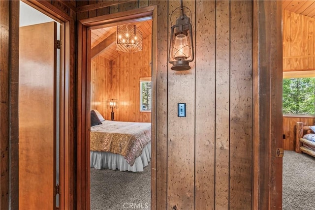 26375 Augusta Dr, Lake Arrowhead, CA 92352 - carpeted bedroom featuring wood walls and an inviting chandelier