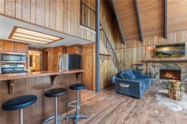 26375 Augusta Dr, Lake Arrowhead, CA 92352 - kitchen featuring open floor plan, appliances with stainless steel finishes, beam ceiling, brown cabinetry, and light wood finished floors
