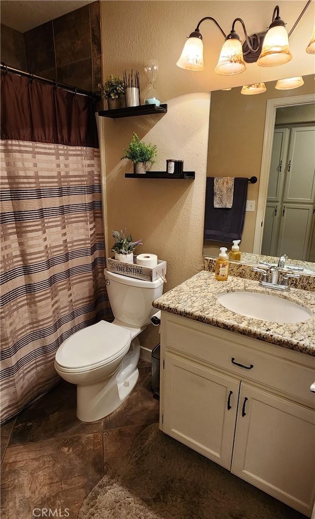 full bathroom with toilet, vanity, a textured wall, and a shower with curtain