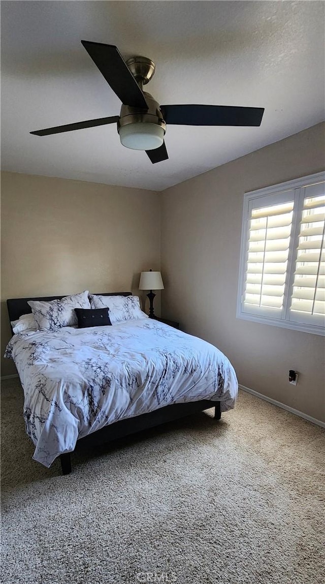 carpeted bedroom with baseboards and ceiling fan