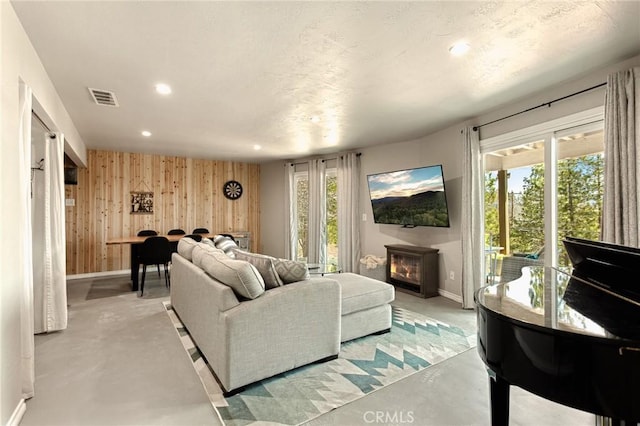 27482 Matterhorn Dr, Lake Arrowhead, CA 92352 - living room with recessed lighting, finished concrete flooring, wood walls, and a glass covered fireplace