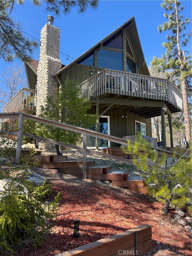 27482 Matterhorn Dr, Lake Arrowhead, CA 92352 - rear view of property featuring board and batten siding, a deck, and a chimney