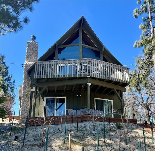 27482 Matterhorn Dr, Lake Arrowhead, CA 92352 - rear view of house with board and batten siding, a chimney, and a deck