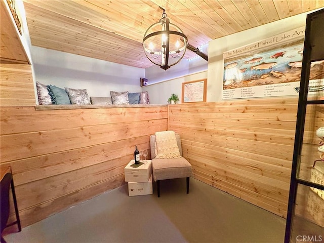 27482 Matterhorn Dr, Lake Arrowhead, CA 92352 - living area featuring concrete floors, a chandelier, wooden ceiling, and wooden walls