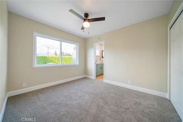 unfurnished bedroom featuring baseboards, light carpet, and a closet