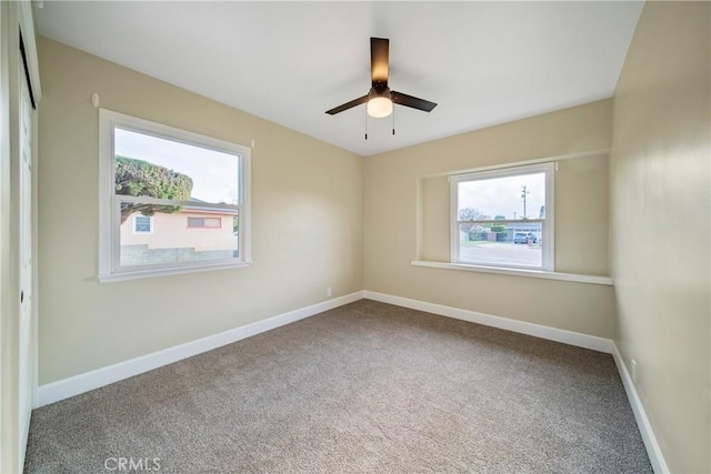 spare room featuring carpet flooring, ceiling fan, and a healthy amount of sunlight