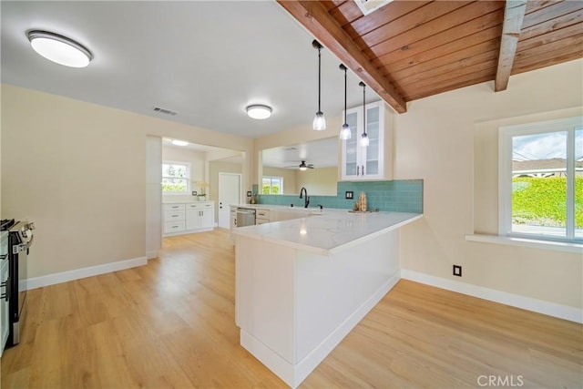 kitchen featuring a peninsula, visible vents, a sink, and light wood-type flooring