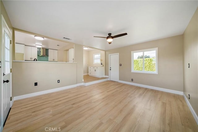 unfurnished living room featuring ceiling fan, visible vents, baseboards, and light wood-type flooring