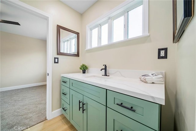 bathroom featuring baseboards, ceiling fan, and vanity