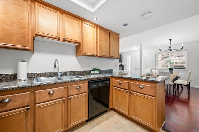 kitchen featuring a peninsula, a sink, brown cabinetry, and black dishwasher