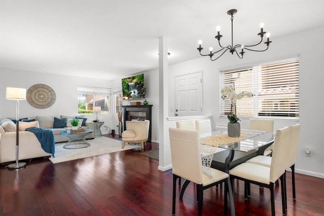 dining room with baseboards, wood finished floors, and a notable chandelier