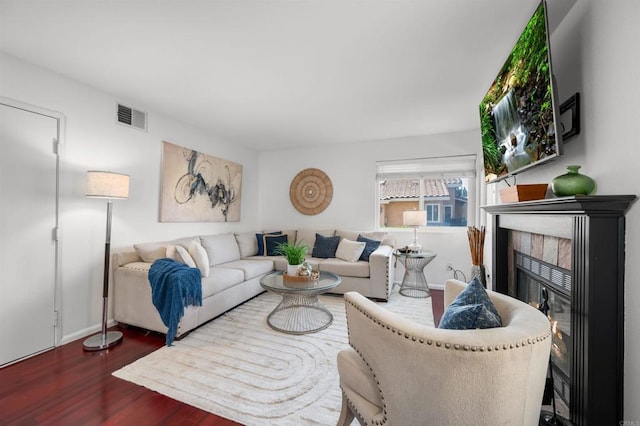 living area featuring wood finished floors, visible vents, and a fireplace