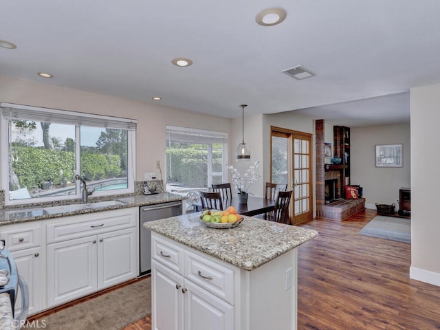 27275 Comba, Mission Viejo, CA 92692 - kitchen featuring dishwasher, a sink, wood finished floors, white cabinetry, and light stone countertops
