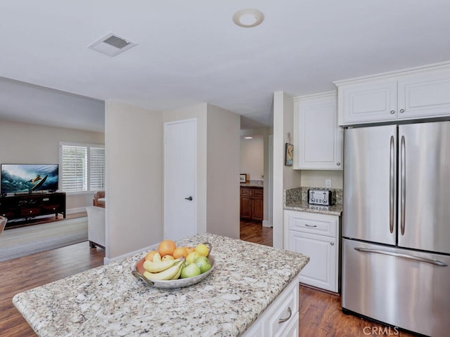 27275 Comba, Mission Viejo, CA 92692 - kitchen featuring stainless steel refrigerator, white cabinetry, light stone countertops, dark wood finished floors, and open floor plan
