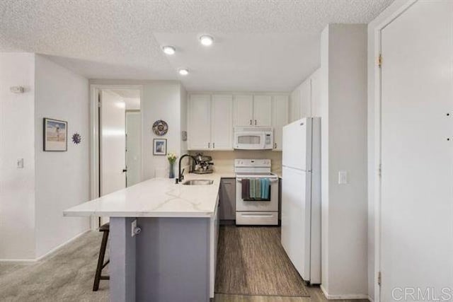 999 N Pacific St Unit G326, Oceanside, CA 92054 - kitchen with white appliances, a sink, a peninsula, white cabinets, and a textured ceiling
