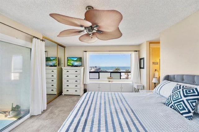 999 N Pacific St Unit G326, Oceanside, CA 92054 - bedroom featuring light colored carpet, a textured ceiling, and ceiling fan