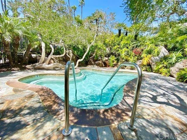 999 N Pacific St Unit G326, Oceanside, CA 92054 - view of swimming pool featuring a pool, view of wooded area, and a hot tub