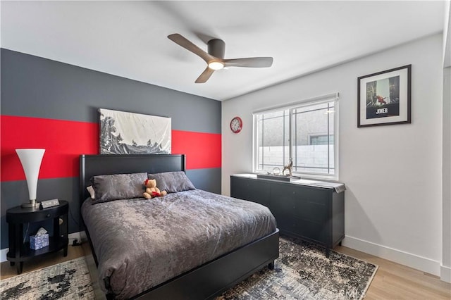 bedroom featuring baseboards, a ceiling fan, and light wood-style floors