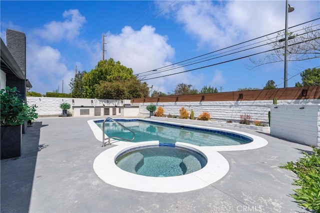 view of pool featuring a patio area, a pool with connected hot tub, and a fenced backyard