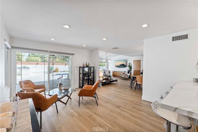 living area with light wood-style floors, baseboards, visible vents, and recessed lighting