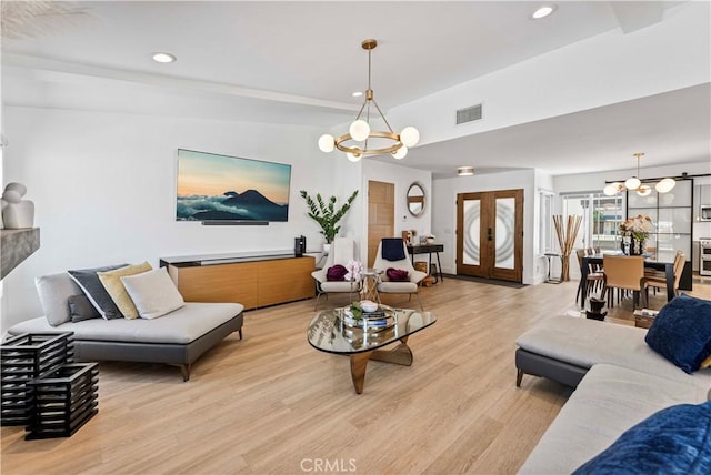 living room featuring recessed lighting, a notable chandelier, and light wood-type flooring