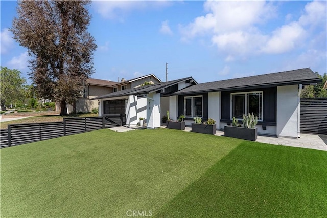 back of property featuring a yard, stucco siding, a patio area, fence, and an attached garage