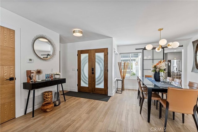 entryway featuring light wood-style floors, baseboards, visible vents, and french doors
