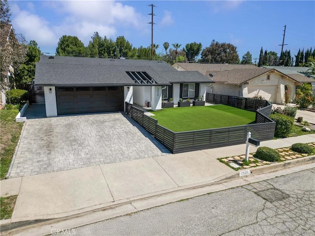 ranch-style home with an attached garage, fence, stucco siding, a front lawn, and driveway