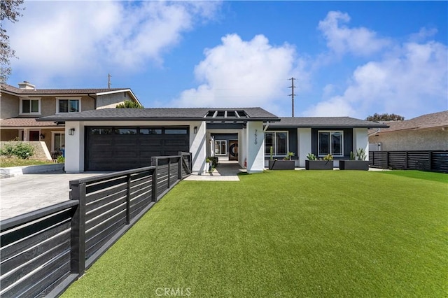 view of front of property featuring stucco siding, a front yard, fence, a garage, and driveway