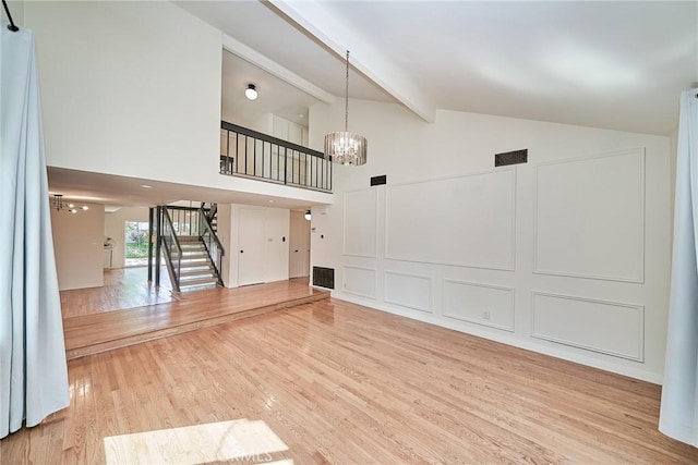 19910 Cantara St, Winnetka, CA 91306 - unfurnished living room with an inviting chandelier, light wood-style flooring, stairs, beamed ceiling, and visible vents