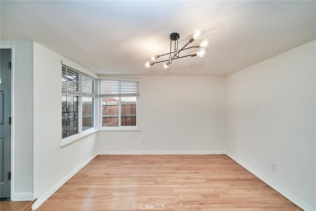 19910 Cantara St, Winnetka, CA 91306 - unfurnished room with an inviting chandelier, light wood-style flooring, and baseboards