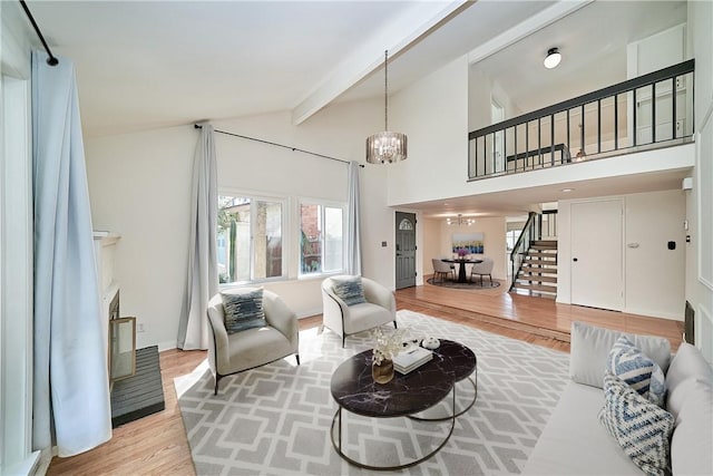 19910 Cantara St, Winnetka, CA 91306 - living area featuring lofted ceiling with beams, an inviting chandelier, a fireplace, light wood-style floors, and stairway