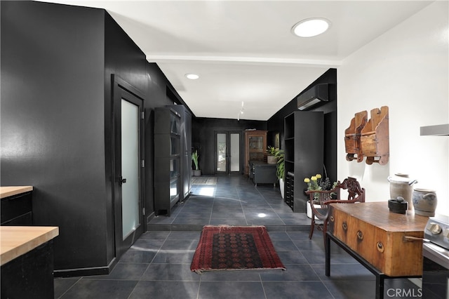 corridor featuring french doors, dark tile patterned floors, and an AC wall unit