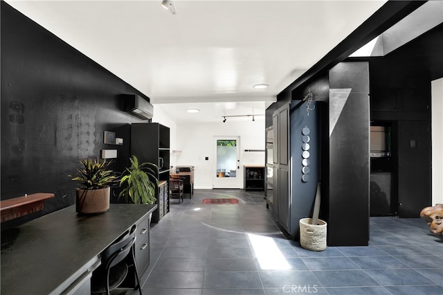 interior space with dark tile patterned floors, recessed lighting, a wall mounted AC, and track lighting