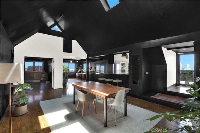 dining room with wood finished floors and high vaulted ceiling