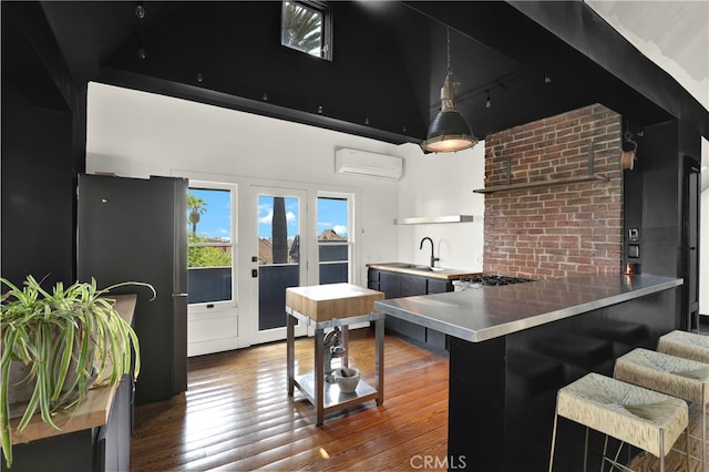 801 E Edgeware Rd, Los Angeles, CA 90026 - kitchen featuring stainless steel countertops, an AC wall unit, open shelves, dark cabinetry, and a sink