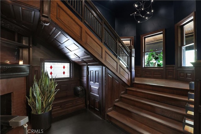 801 E Edgeware Rd, Los Angeles, CA 90026 - stairs with healthy amount of natural light, a brick fireplace, a chandelier, and vaulted ceiling