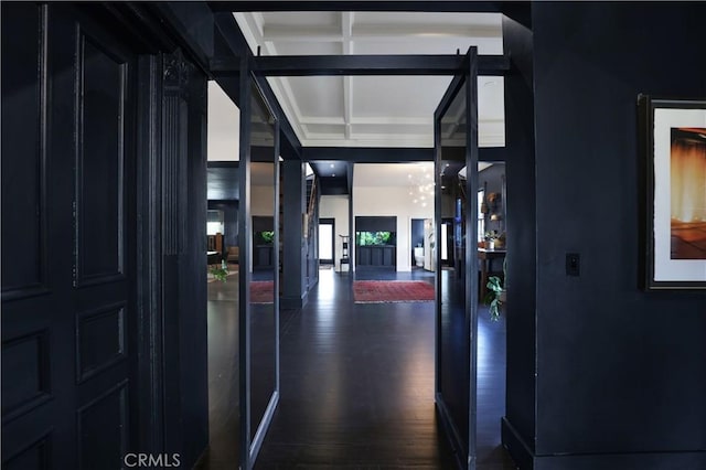 hall featuring coffered ceiling, dark wood-style flooring, and beamed ceiling
