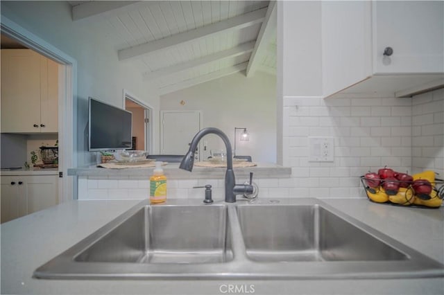 1345 Cabrillo Park Dr Unit J02, Santa Ana, CA 92701 - kitchen featuring a sink, decorative backsplash, white cabinets, light countertops, and wood ceiling